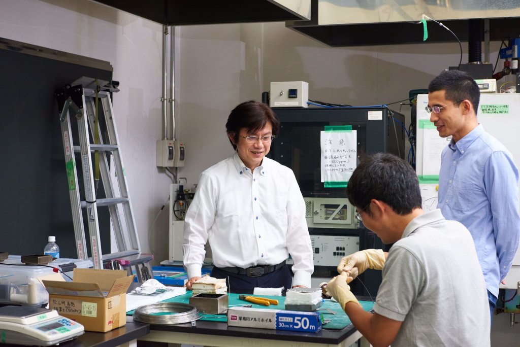研究室で作業をしている松山教授と研究室の男性2名